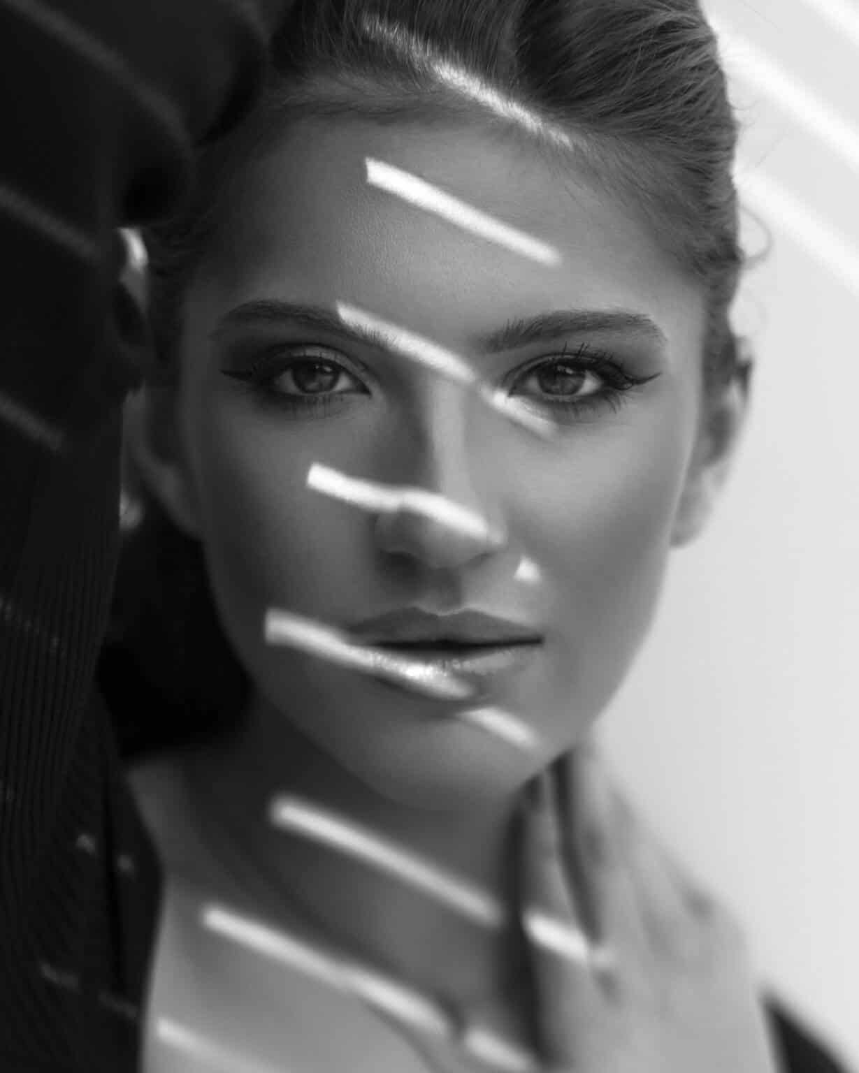 Black-and-white beauty portrait by Marcus Boéll – model with light and shadow stripes across her face
