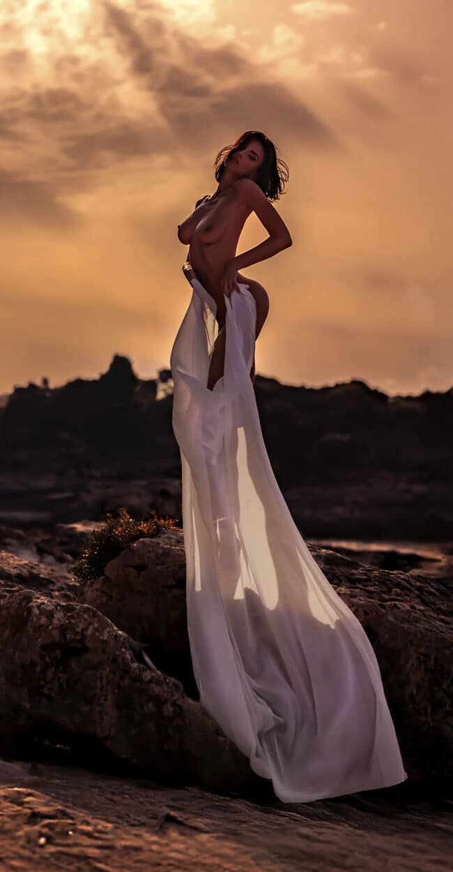 Portrait at sunset in Ses Salines, Mallorca – model wrapped in a long white fabric on the coastal rocks